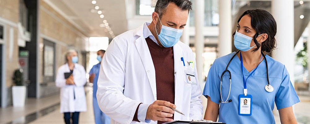 Mature doctor and nurse discussing patient case IDP Card Printing solutions for the medical and healthcare market.